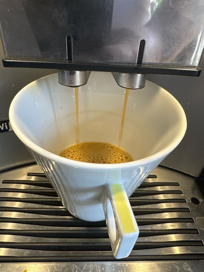 Fresh espresso crema brewing from espresso roast coffee beans.